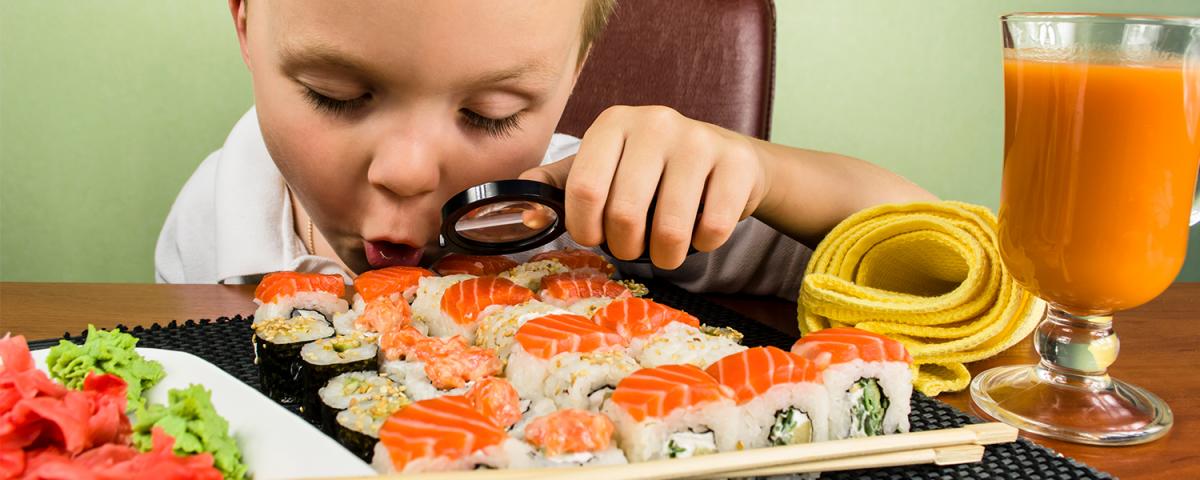 Kid investigating sushi with magnifying glass